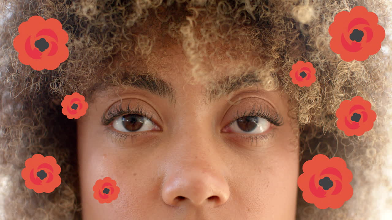 Red flowers animation over close-up of person's face with curly hair