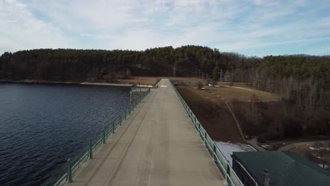 Flying-across-the-Wachusett-Reservoir-Dam-walkway-in-Clinton,-Massachusetts