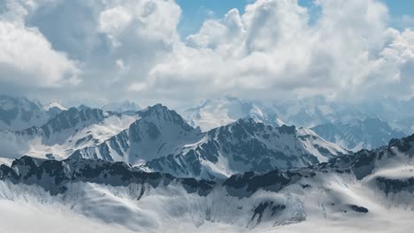 air flight through mountain clouds over beautiful snow-capped peaks of mountains and glaciers.