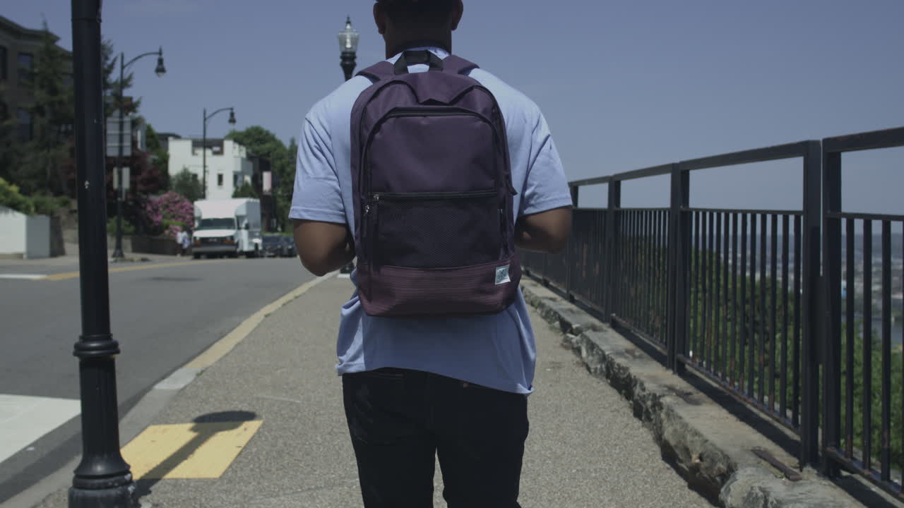 4k uhd에서 안정화된 도시에서 걷고 있는 아프리카계 미국인 관광객의 샷을 돌고 따라가세요