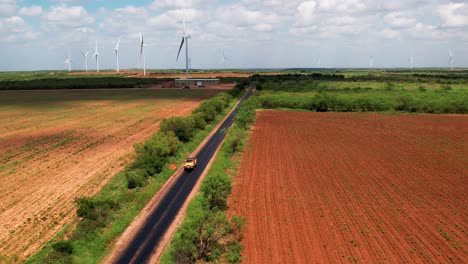 jeep truck coming down country road in a wind farm