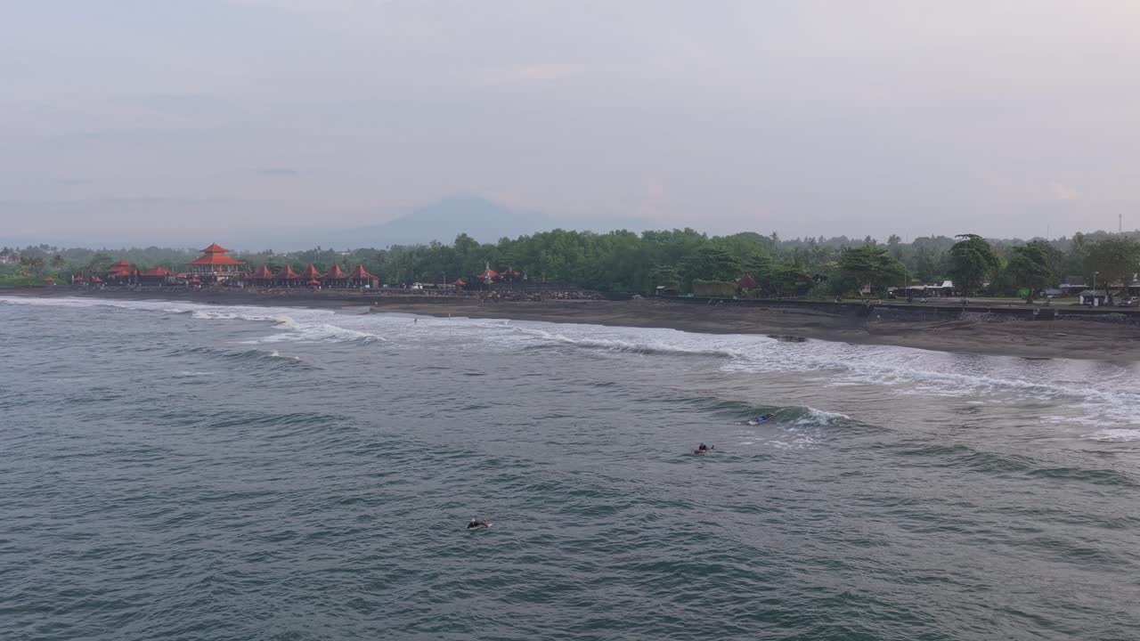 Surfaři sjíždějící vlny na pláži Kedungu na Bali v Indonésii.