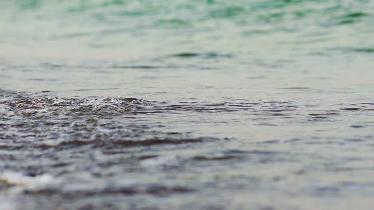 Sea waves with foam beat on the sandy coast in warm weather in the summer. Tides. Beauty of nature.
