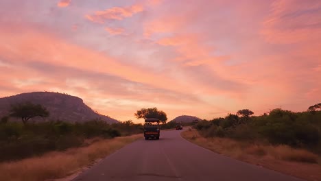 Silhouette-of-safari-vehicle-on-the-brow-of-a-hill-at-sunset-with-golden-sunlight,-Kruger-National-Park,-South-Africa