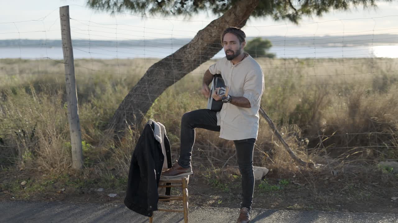 야외에서 어쿠스틱 기타를 연주하는 남자