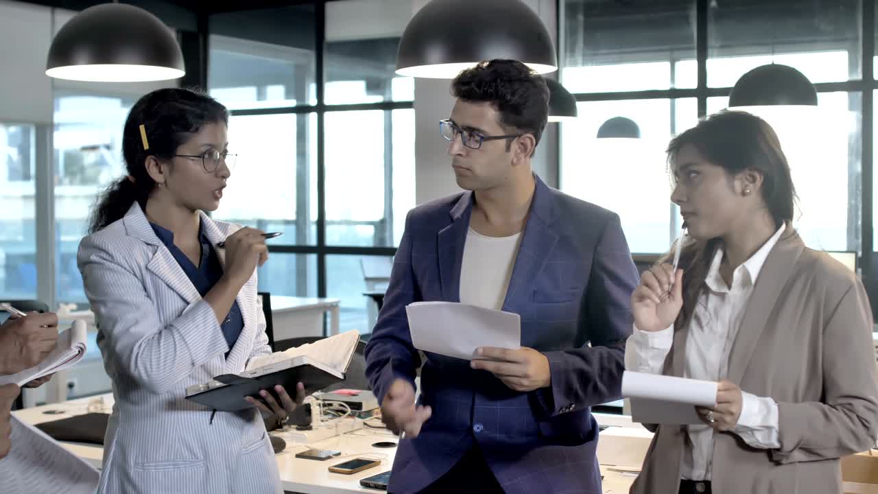 창의적인 팀과 함께 서서 프로젝트에 대한 브리핑을 제공하는 똑똑한 여성 그룹 리더 또는 보스.