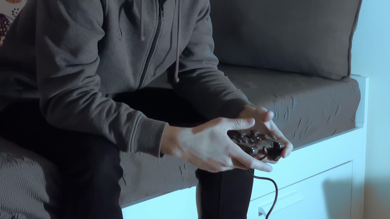 hombre adulto jugando videojuegos en el sofá