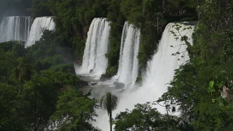 espectacular vista lejana de hermosas cascadas en el pintoresco paisaje de vegetación de la selva, increíble grupo de cascadas que caen de enormes acantilados en hermosas condiciones soleadas en las cascadas de iguazú, argentina