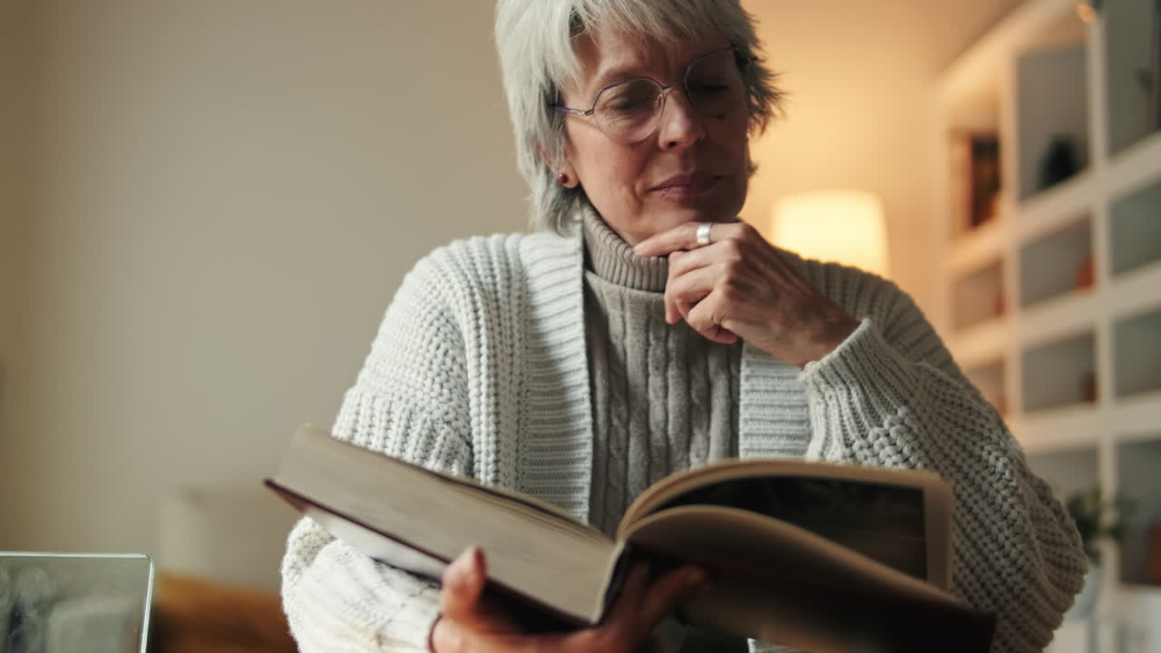 Senior Woman Looking Through Old Photo Album at Home