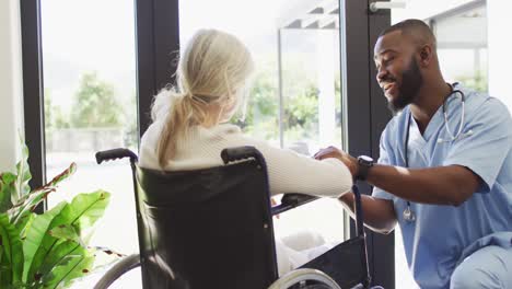 video of happy african american male doctor taking care of caucasian senior woman