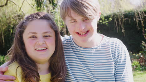 outdoor portrait of loving young downs syndrome couple in garden at home together