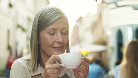 Nahaufnahme-Einer-Schönen-Seniorin-Mit-Grauem-Haar,-Die-Im-Café-Im-Freien-Kaffee-Trinkt-Und-Denkt-Oder-Träumt