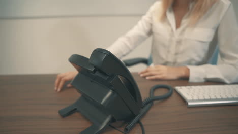 female with face mask having a business call in the office