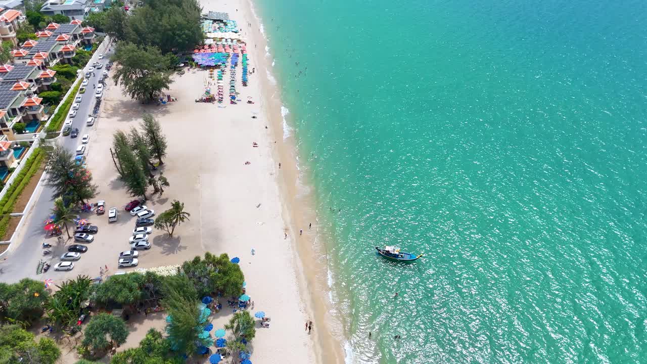 Captura de dron en picado de olas oceánicas turquesas que llegan a una playa de arena blanca y complejos turísticos costeros