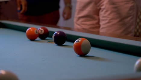 toma en cámara lenta de un hombre jugando al billar o al billar golpeando juntos la bola blanca