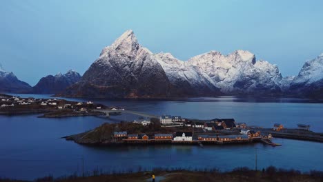 picturesque landscape of small town on seashore surrounded by massive mountains