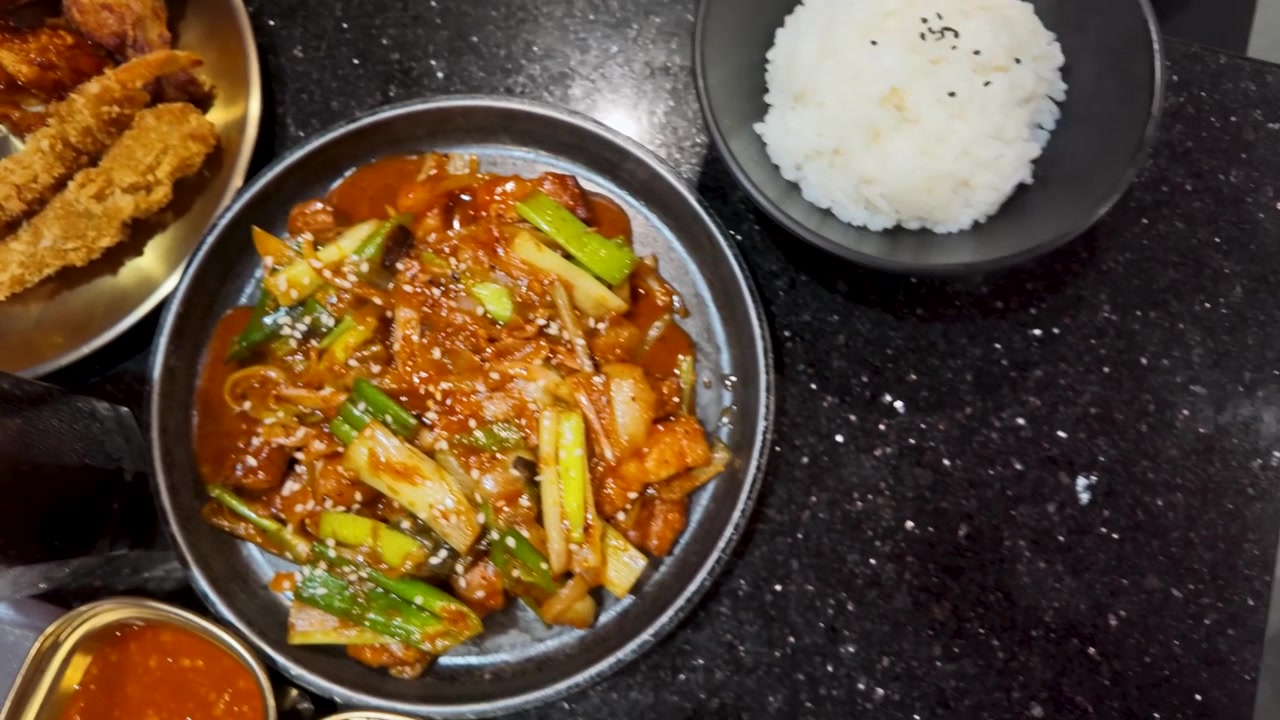 Seseorang Makan Daging Babi Tumis Pedas Korea dengan Sumpit