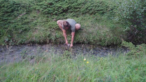 Chico-Noruego-Limpiando-Pescado-Fresco-En-Un-Río-Que-Fluye-Cerca-De-Donnmannen-En-Noruega