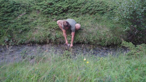 chico noruego limpiando pescado fresco en un río que fluye cerca de donnmannen en noruega