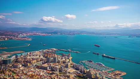 la ciudad de gibraltar escapa el lapso de tiempo cuando los barcos entran en el puerto y las sombras de las nubes pasan sobre los edificios.