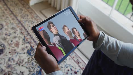 composite of man sitting at home, watching sports event on tablet