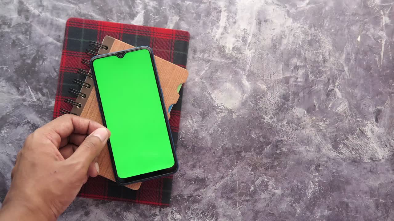 vista superior de la mano de un hombre usando un teléfono inteligente sobre un fondo negro