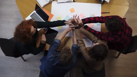 european happy team of business people students stack hands in pile together as teamwork and help, friendship concept, support in group work, unity trust cooperation. footage from above. slow motion