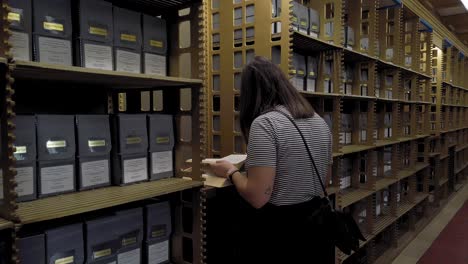slow motion of female searching for documents in new york city public library