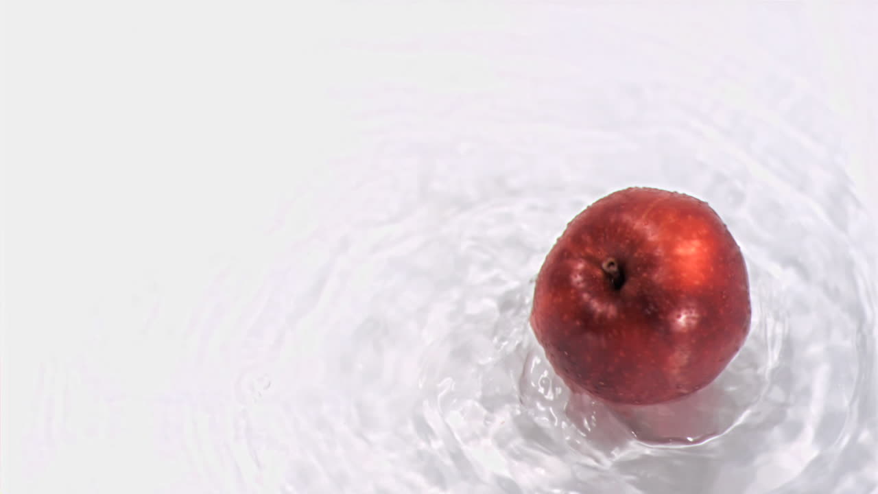 Mela che ruota nell'acqua in super slow motion