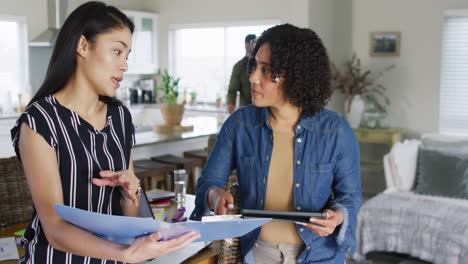 diverse female friends talking, using tablet, working at home, in slow motion