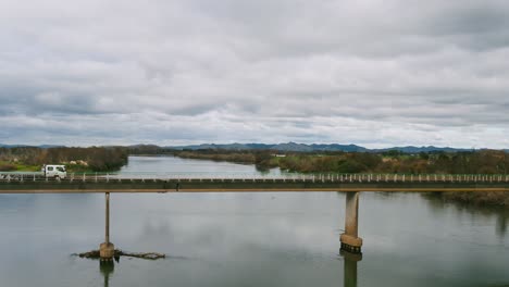 empty flatbed truck crosses river bridge, waikato new zealand