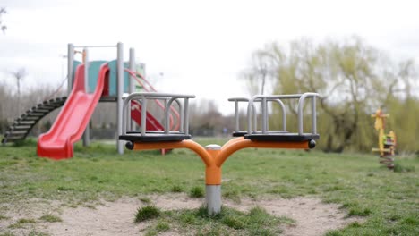 rotating swing slide and horse in an empty park with no children playing due to quarantine lock down for pandemic virus epidemy alert