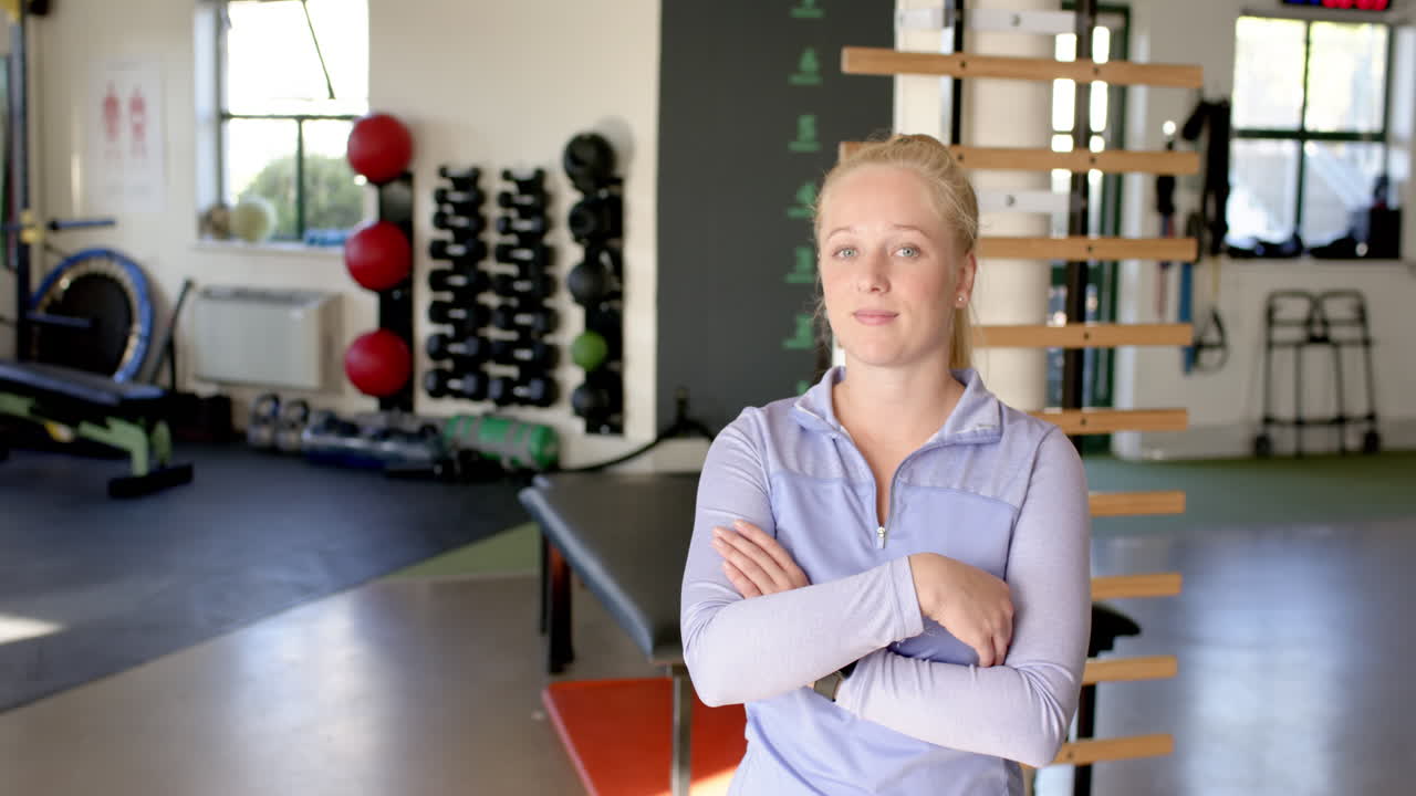 In rehabilitation center, female therapist standing with arms crossed, copy space