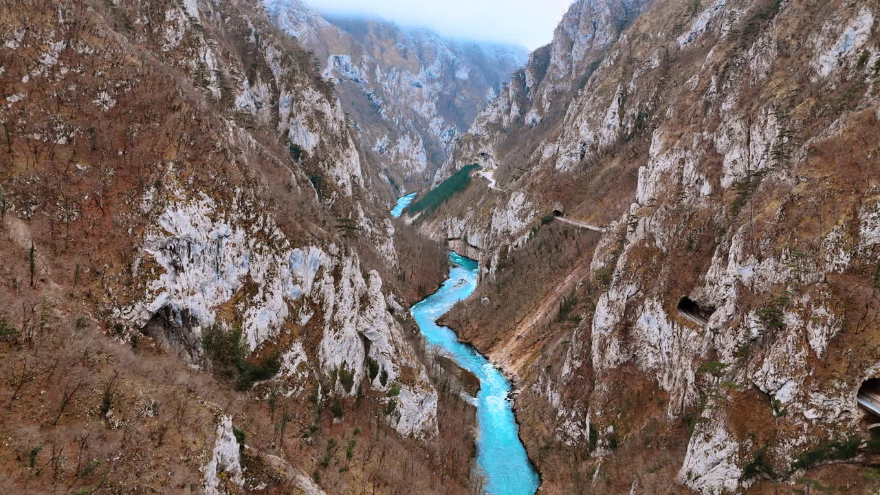 Dòng sông màu ngọc lam uốn lượn qua hẻm núi đá dốc ở Montenegro. Quang cảnh trên không dòng nước xanh biếc chảy dưới chân những vách đá hùng vĩ trong phong cảnh Montenegro.