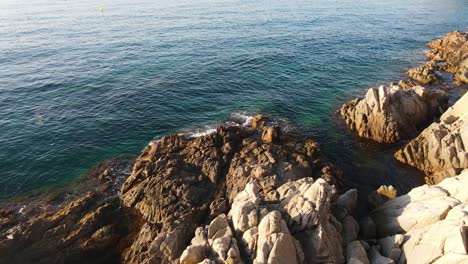 Rocas-Bañadas-Por-Olas-De-Mar-Azul-En-La-Irregular-Costa-De-Blanes-En-España