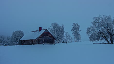 Zeitrafferaufnahme-Eines-Holzhauses-In-Der-Ferne,-Bedeckt-Mit-Dicken-Schneeschichten-An-Einem-Kalten-Wintertag