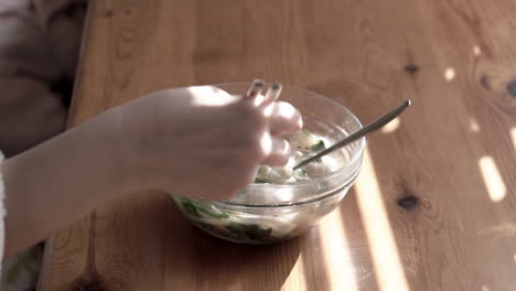 close up young woman hands using chopsticks to eat chinese noodles for breakfast