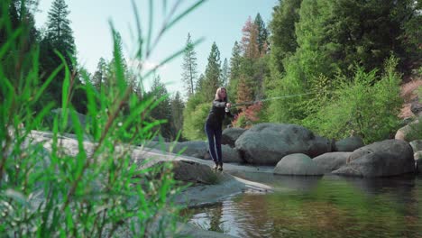 low angle, blonde woman casting, fly fishing in rocky mountain river