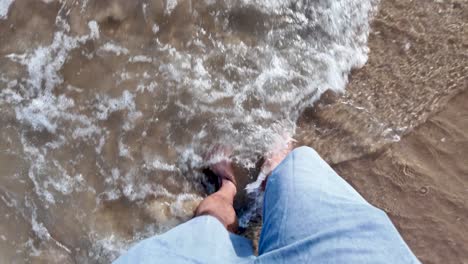 Pov of legs walking barefoot on the seashore, enjoying the waves on vacation. Slow Motion