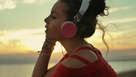 teenager girl with headphones listening music on the beach. shot in slow motion