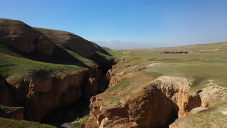 Fast-cinematic-drone-shot-of-a-large-ravine-near-the-Kel-Suu-in-Kyrgyzstan