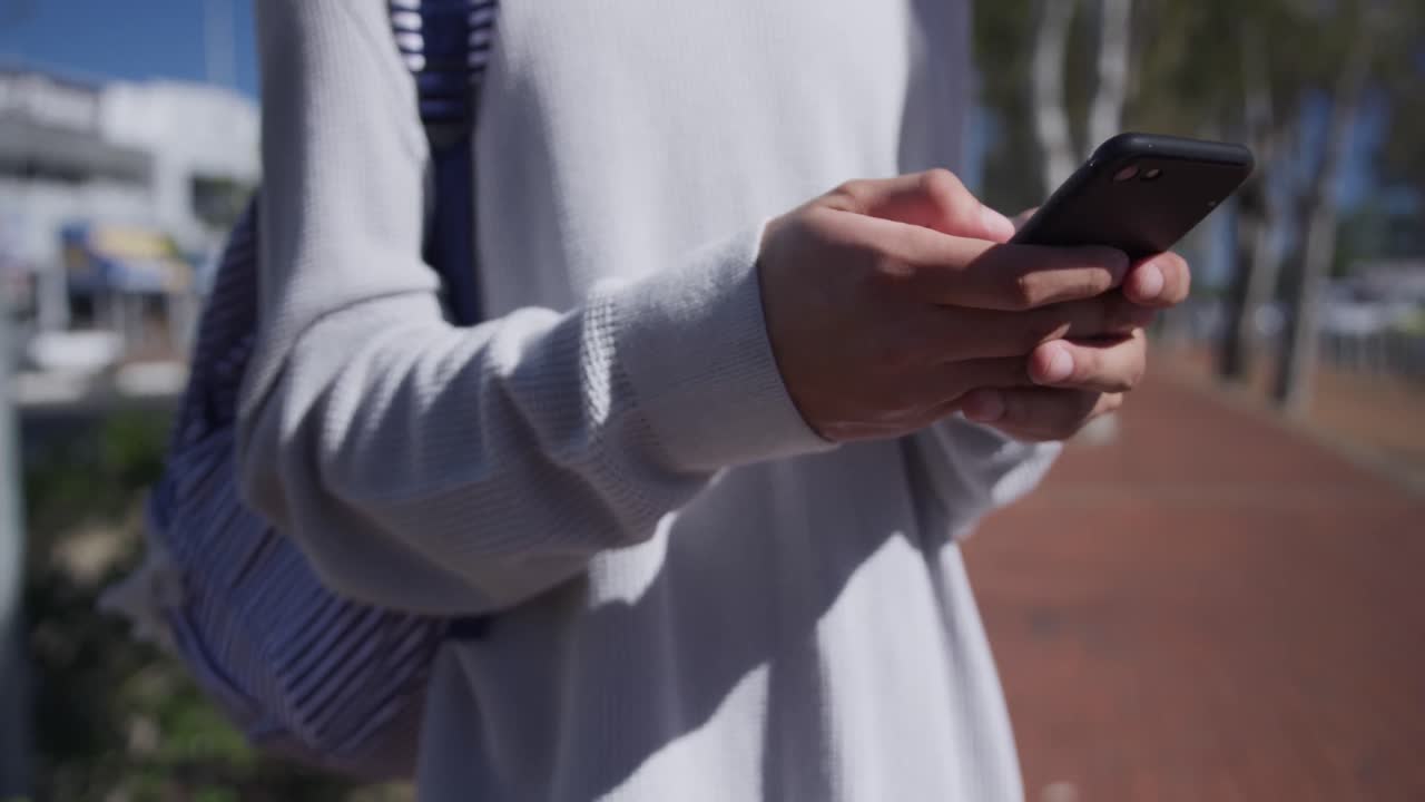 Persona adulta transgender che usa un telefono per strada