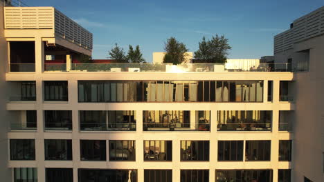 Vista-Aérea-Frente-A-Las-Ventanas-Reflectantes-De-Un-Condominio,-Que-Revelan-El-Paisaje-Urbano-De-Brooklyn,-Hora-Dorada-En-Ny,-Ee.uu.---Ascendente,-Disparo-De-Drones