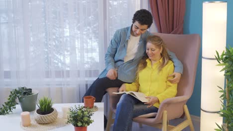 madre e hijo leyendo un libro juntos en casa.