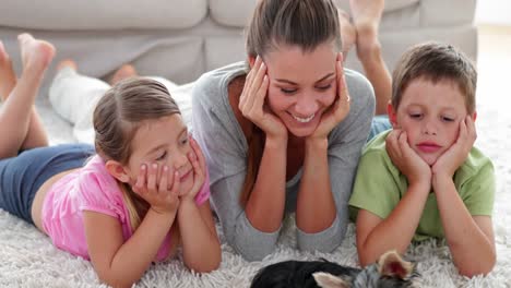 Siblings-playing-with-puppy-with-their-mother-on-the-rug