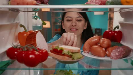 woman looking for food in refrigerator