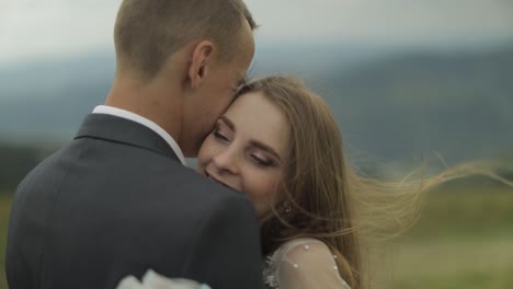 Groom-with-bride-having-fun-on-a-mountain-hills.-Wedding-couple-hugging