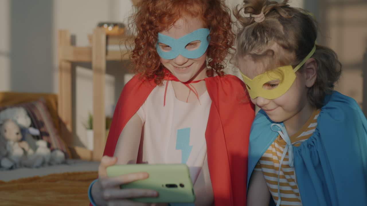 Two Girls in Superhero Costumes Taking a Selfie