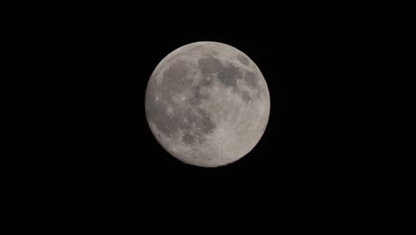 full moon moves quickly in the dark sky