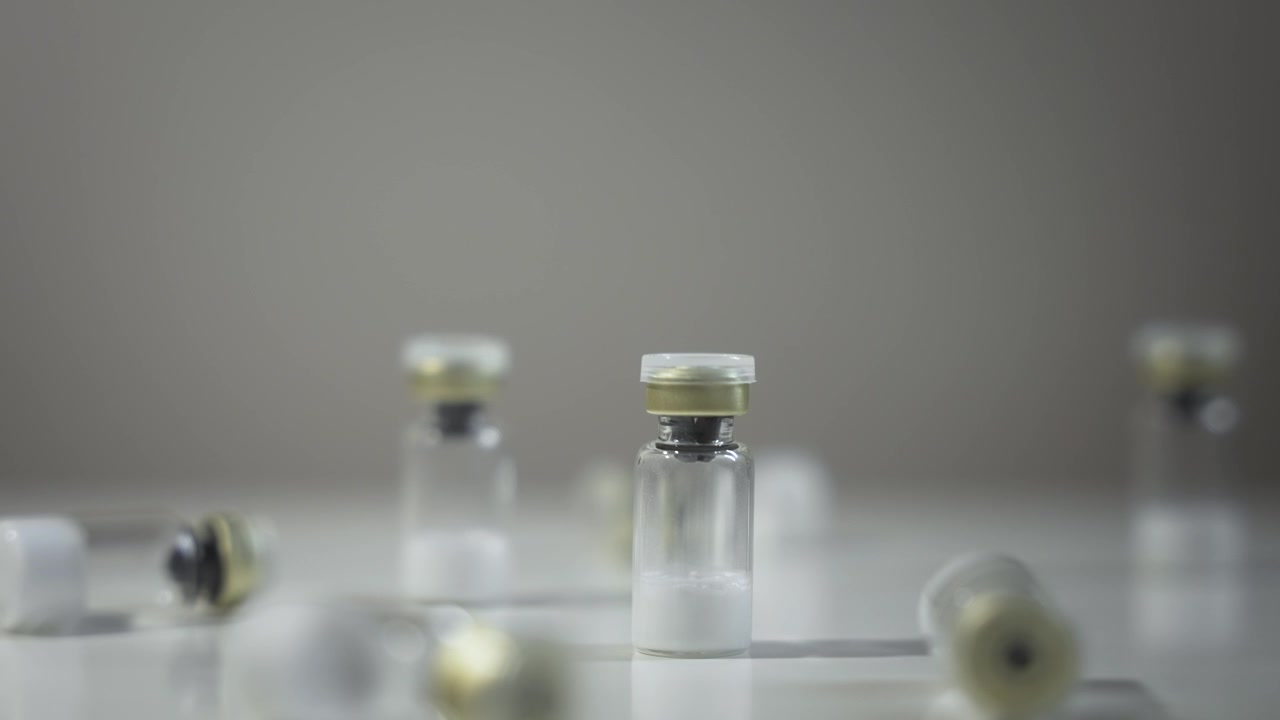 Una mano prende una fiala e la ripone sul tavolo, inquadratura statica [Peptide]